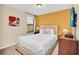 Cozy bedroom with a beige cushioned queen bed, bedside table, and wall-mounted TV at 2630 Tranquility Way, Kissimmee, FL 34746