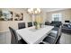 Elegant dining area with a large table, modern chairs, and stylish decor with a view to the living room at 2630 Tranquility Way, Kissimmee, FL 34746