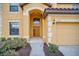 Home exterior featuring landscaped entrance, a two car garage, and address number 2630 above the door at 2630 Tranquility Way, Kissimmee, FL 34746