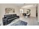 Stylish living room with modern furniture, a decorative mirror, and an open view to the dining area at 2630 Tranquility Way, Kissimmee, FL 34746
