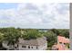 Picturesque view of rooftops, trees, and a serene lake in the distance under a partly cloudy sky at 265 E Canton Ave # Ge, Winter Park, FL 32789