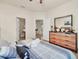 Bright main bedroom featuring a decorative dresser, ensuite bathroom, and comfortable patterned bedding at 2736 Oakwater Dr, Kissimmee, FL 34747