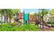 Colorful playground equipment with slides, climbing structure, and green bushes in a tropical landscape at 2736 Oakwater Dr, Kissimmee, FL 34747