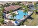Aerial view of a community pool with palm trees, lounge chairs, and nearby residences at 2736 Oakwater Dr, Kissimmee, FL 34747