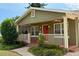 Charming bungalow featuring a cozy front porch with a red door and meticulously landscaped yard at 2810 Elizabeth Ave, Orlando, FL 32804