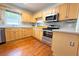 Kitchen featuring wooden cabinets, stainless steel appliances, and hardwood floors at 2810 Elizabeth Ave, Orlando, FL 32804