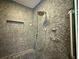 Custom shower with stone pebble wall and rainfall shower head, designed for spa-like experience at 2810 Elizabeth Ave, Orlando, FL 32804