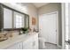 Well-lit bathroom featuring a white vanity, decorative mirror, and patterned tile flooring at 2821 Columbus Ave, Clermont, FL 34715