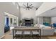 Sun-filled living room with tall ceilings, fan, tv, sliding doors to outdoor living and kitchen in background at 2821 Columbus Ave, Clermont, FL 34715
