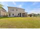 Large green backyard with a screened-in patio, and a black metal fence at 2901 Harvest Hill Ln, Orlando, FL 32824