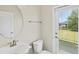 Powder room featuring modern fixtures, a round mirror, and a door with blinds leading to the outside at 2901 Harvest Hill Ln, Orlando, FL 32824