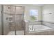 Bathroom featuring tiled shower and soaking tub with decorative tile accent and window at 2901 Harvest Hill Ln, Orlando, FL 32824
