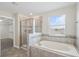Relaxing bathroom with shower, soaking tub, and tile accents, complemented by natural light from a large window at 2901 Harvest Hill Ln, Orlando, FL 32824