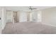 Large bedroom with neutral-toned carpet, a ceiling fan, and multiple doors for closet and hallway access at 2901 Harvest Hill Ln, Orlando, FL 32824