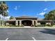 Community clubhouse with lush landscaping, a tile roof, and parking in front at 2901 Harvest Hill Ln, Orlando, FL 32824