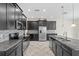 Open kitchen features black cabinets, granite counters, stainless appliances, and tile backsplash at 2901 Harvest Hill Ln, Orlando, FL 32824