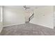 Open-concept living room with gray tile flooring, ceiling fan, and staircase leading to the second floor at 2901 Harvest Hill Ln, Orlando, FL 32824