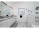 Bright bathroom with a double vanity, modern mirrors, and a glass-enclosed shower at 2902 Paddington Way, Kissimmee, FL 34747