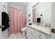 Bathroom with a white granite sink, white marble tiles, and a pink shower curtain at 2902 Paddington Way, Kissimmee, FL 34747