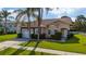 Inviting single-story house featuring a stone facade, two-car garage, and manicured lawn at 2902 Paddington Way, Kissimmee, FL 34747