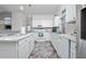 Bright kitchen featuring white cabinetry, modern appliances, and stylish herringbone flooring at 2902 Paddington Way, Kissimmee, FL 34747