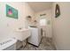 Bright laundry room with washer, dryer, sink, and beach themed decor at 2902 Paddington Way, Kissimmee, FL 34747