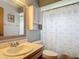 Cozy bathroom featuring a shower with a patterned curtain, a vanity, and grey cabinets at 3110 Short Leaf Pine Ct, Kissimmee, FL 34746