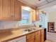 Traditional kitchen features wood cabinets and a stainless steel sink with pass through window to dining area at 3110 Short Leaf Pine Ct, Kissimmee, FL 34746