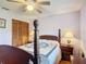 Bedroom featuring a four-poster bed, ceiling fan, and closet with louvered doors at 3110 Short Leaf Pine Ct, Kissimmee, FL 34746