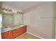 This bathroom features a double sink vanity with a large mirror and tiled flooring at 3151 Sinclair St # 104, Orlando, FL 32835