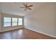 Bright bedroom featuring wood-look flooring, a ceiling fan and bright, natural light from the three windows at 3151 Sinclair St # 104, Orlando, FL 32835
