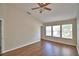 Spacious bedroom featuring wood-look flooring, a ceiling fan and bright, natural light from the three windows at 3151 Sinclair St # 104, Orlando, FL 32835