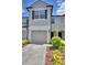 Townhome showcasing a one-car garage and well-maintained front yard at 3151 Sinclair St # 104, Orlando, FL 32835