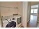 This laundry room is equipped with a newer model Samsung washer and dryer and a storage shelf at 3151 Sinclair St # 104, Orlando, FL 32835