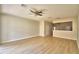 Open-concept living room with light wood flooring and a ceiling fan, flowing into the adjacent areas at 3151 Sinclair St # 104, Orlando, FL 32835