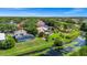 Aerial view of a home's landscaped backyard with a screened pool, lush greenery and a tranquil pond at 3170 Zaharias Dr, Orlando, FL 32837
