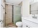 Bathroom with shower featuring decorative tile and glass door, plus a white sink and toilet at 3170 Zaharias Dr, Orlando, FL 32837