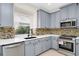 Kitchen with gray cabinets, stainless steel appliances, and white quartz countertops at 3170 Zaharias Dr, Orlando, FL 32837