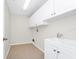 Laundry area features white cabinets above sink, utility connections, and neutral tile flooring at 3170 Zaharias Dr, Orlando, FL 32837