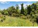 Lush backyard featuring healthy grass, mature trees and landscaping provides a private outdoor space at 3378 Sagebrush St, Harmony, FL 34773