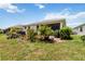 Large backyard with brick patio, perfect for entertaining, featuring colorful garden and mature trees at 3378 Sagebrush St, Harmony, FL 34773