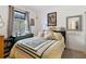 Bright bedroom with a patterned quilt, black accents, and a window with a garden view at 3378 Sagebrush St, Harmony, FL 34773