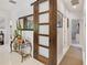 Hallway with a sliding wood door, sleek mirror and adjacent rooms, provides a sense of flow and style at 3378 Sagebrush St, Harmony, FL 34773