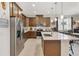 Modern kitchen with stainless steel appliances, a large island, and stylish brown cabinetry at 3378 Sagebrush St, Harmony, FL 34773