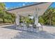 Outdoor kitchen space with bar seating, a built-in grill, and a shaded roof at 3378 Sagebrush St, Harmony, FL 34773