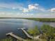 Aerial view of the lake featuring a wooden dock and the surrounding green landscape at 3425 Middlebrook Pl, Harmony, FL 34773