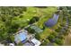 Aerial view showcasing community amenities including pool, tennis courts, golf course, and a scenic pond at 3425 Middlebrook Pl, Harmony, FL 34773