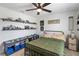 Bedroom with a large bed, ceiling fan, neutral carpeting, and shelves for storage at 3425 Middlebrook Pl, Harmony, FL 34773