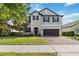 Charming two-story home with stone accents, a manicured lawn, and a brick driveway at 3425 Middlebrook Pl, Harmony, FL 34773