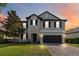 Beautiful two-story home featuring a stone facade, lush lawn and attached two car garage at 3425 Middlebrook Pl, Harmony, FL 34773